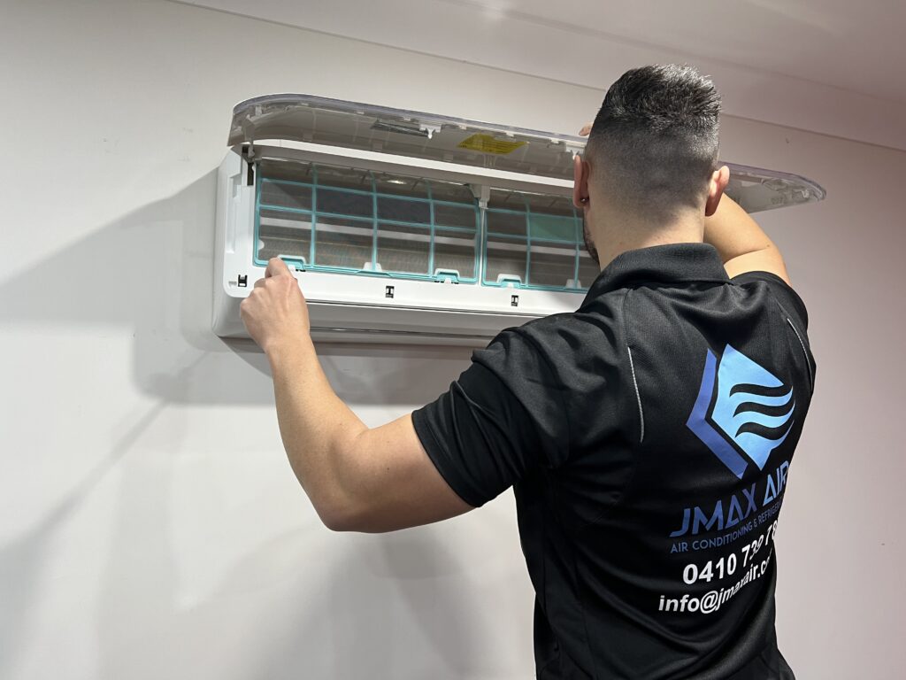 Prevent mould, dust and breakdowns – schedule your air conditioning maintenance with Jmax Air today Technician cleaning air conditioner filters during routine maintenance service